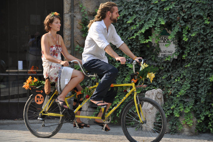 Arriving at the wedding on a yellow tandem bicycle.