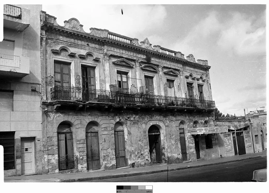 Historical photo, catalogued to around 1979: the Medio Mundo tenement's façade at Cuareim 1080, worn but still standing, with a club's sign over a ground-floor storefront.