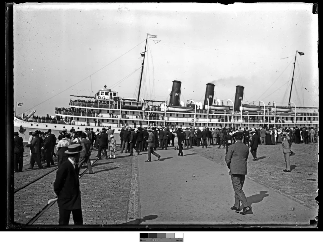 Historical photo, 1916: a three-funnel ocean liner at Dársena I, a well-dressed Sunday crowd on the quay of the finished port.