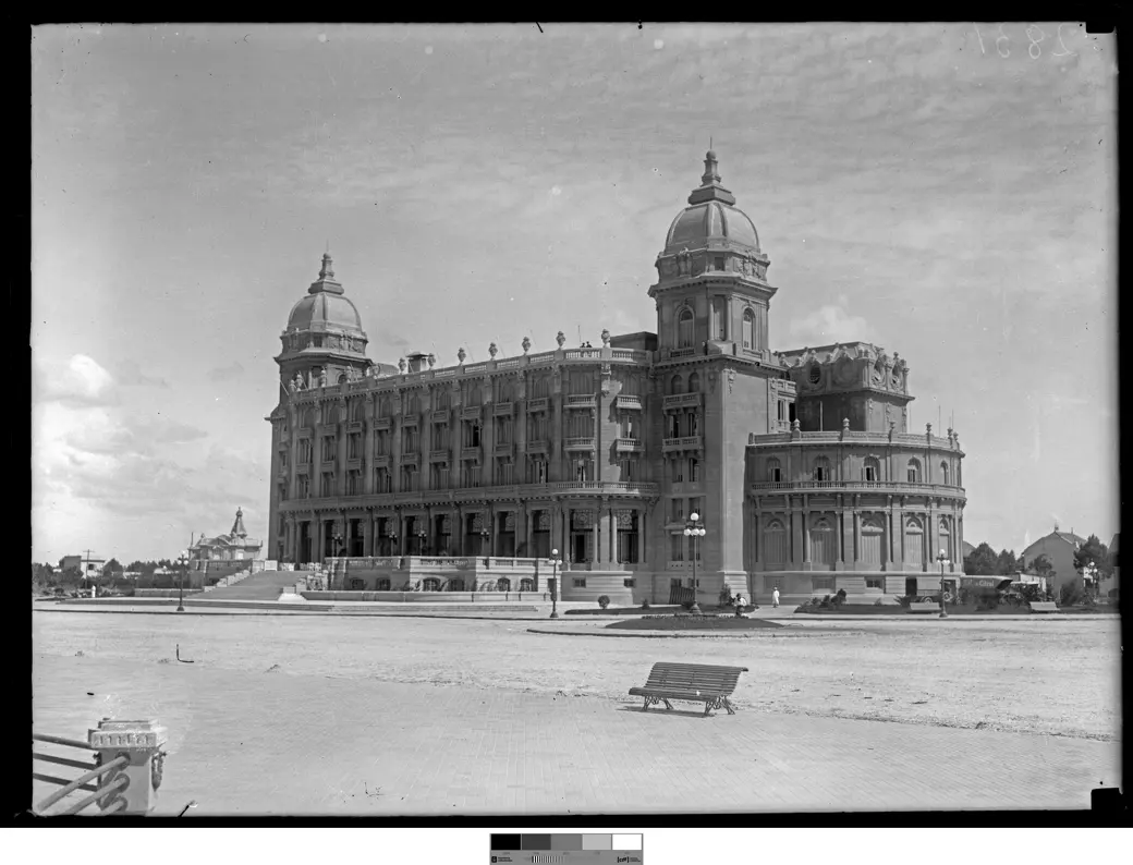 Historical photo, 1921: the newly opened Hotel Carrasco standing alone on a vast expanse of empty sand, with a wooden bench in the foreground.