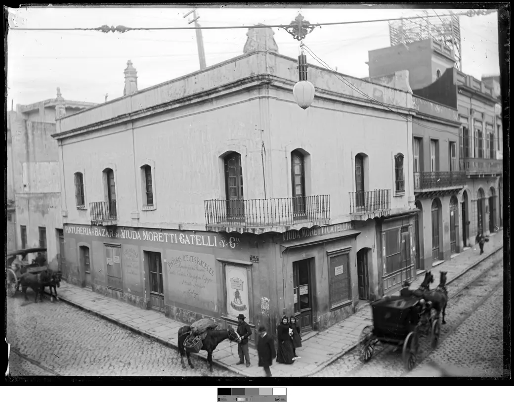 Historical photo, circa 1900: the corner of Rincón and Bartolomé Mitre, with carts on both sides and pedestrians walking directly on the cobblestones.