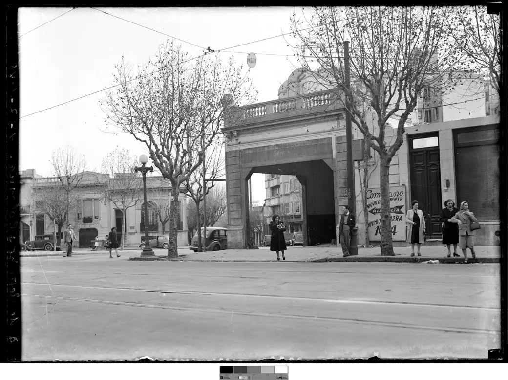 Undated historical photo, approx. 1930s-40s: the Tres Cruces bus stop, with cars parked at the curb and pedestrians confined to the sidewalk.