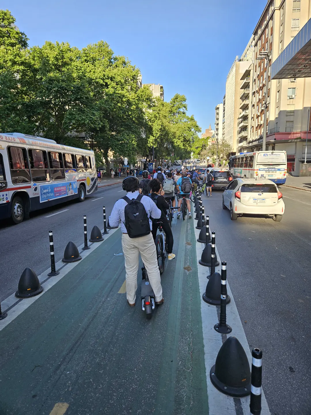 The bike lane down the axis of 18 de Julio, with bicycles and scooters riding down the middle of the roadway.
