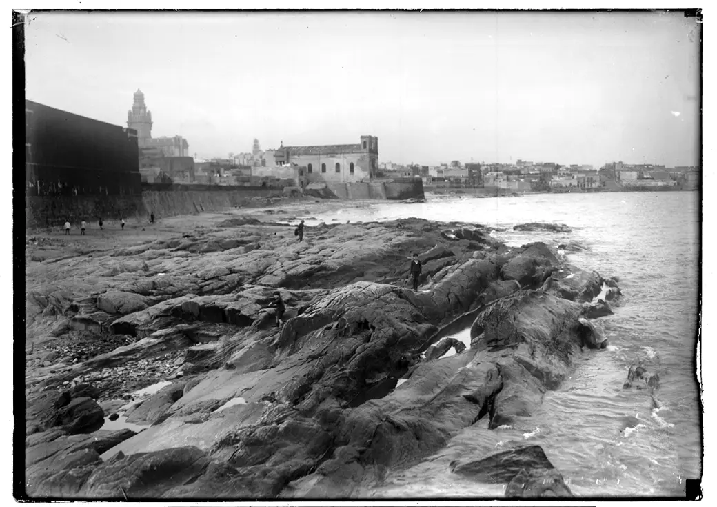 Historical photo, 1928–1935: open rock at Rambla Francia and Calle Alzáibar, mid-construction, Palacio Salvo and the Templo Inglés in the distance.