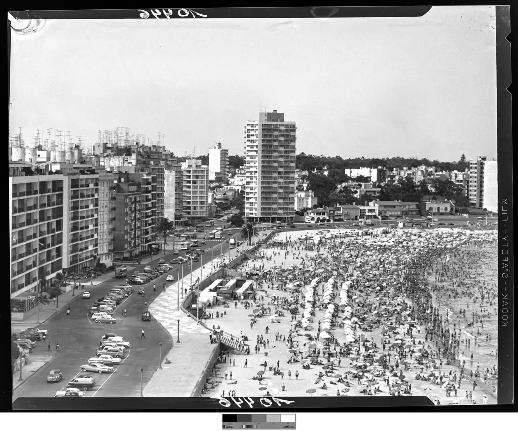 Historical photo, January 1964: Pocitos beach and rambla, packed sand and cars parked along the whole curb.