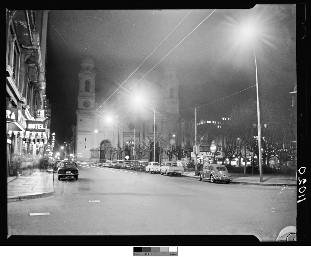 Historical photo, August 1966: cars at the curb on Plaza Constitución, with the floodlit tower of the Iglesia Matriz behind.